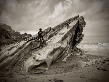 Man standing on rock at beach