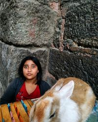 Portrait of young woman by rabbit