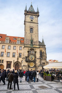 People walking in front of clock tower