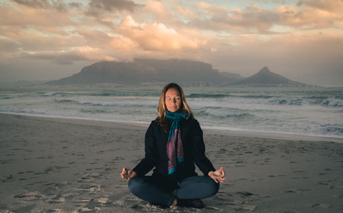 Woman meditating on beach