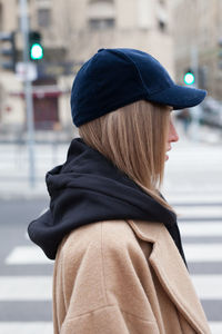 Side view of woman standing on street during winter