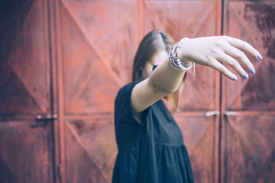 Close-up of young woman showing fingernails with nail polish