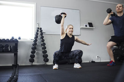 Two people lifting weights in gym