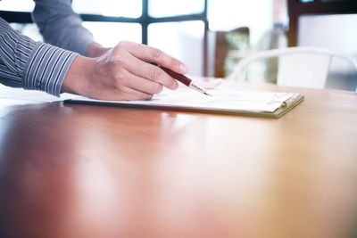 Cropped hands of businessman analyzing data on desk in office