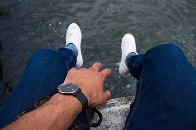 Low section of men sitting by water