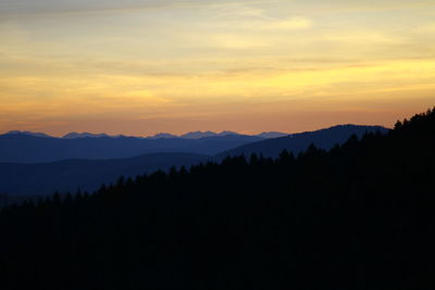 Scenic view of silhouette mountains against sky at sunset