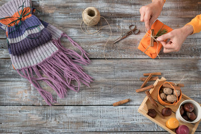 High angle view of woman tying gift during christmas on table