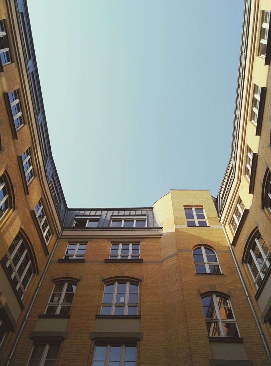 architecture, building exterior, built structure, clear sky, low angle view, window, city, building, residential building, residential structure, city life, balcony, day, apartment, copy space, outdoors, modern, sky, office building, tall - high