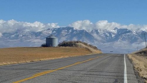 Empty road with mountains in background