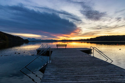 Pier over lake against sky during sunset