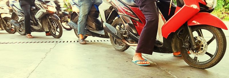 Low section of people walking on street in city