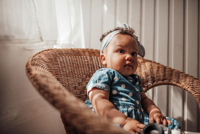 Portrait of cute girl sitting at home