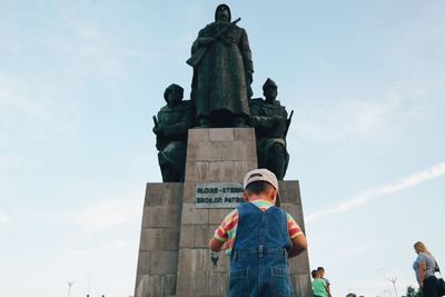 Low angle view of woman standing against sky