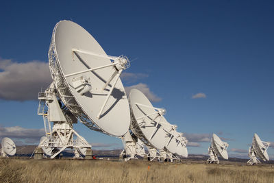 Low angle view of array on field against sky