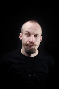 Portrait of confident man against black background