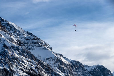 Low angle view of snowcapped mountains against sky