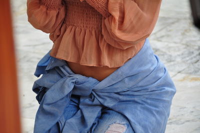 Midsection of woman standing against blurred background