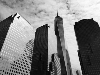 Low angle view of skyscrapers against cloudy sky