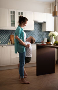 Mother playing with son in kitchen