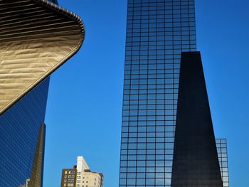 Low angle view of modern buildings against blue sky