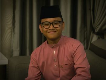 Portrait of smiling teenager boy wearing traditional clothes at home