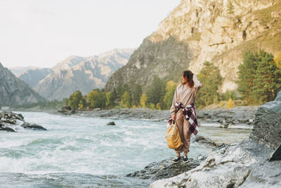 Man standing on rock by mountains