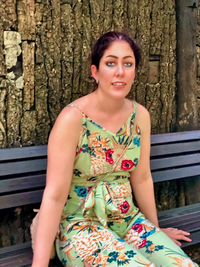 Portrait of smiling young woman sitting on bench