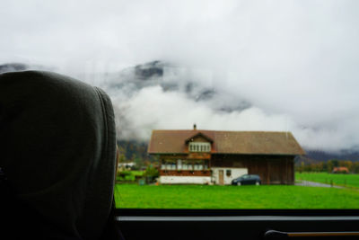 Houses by mountains against sky during winter
