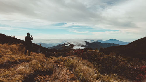 Man standing on snow covered landscape against sky