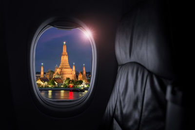 Airplane interior with window view of wat arun, or the temple landmark of thailand, 