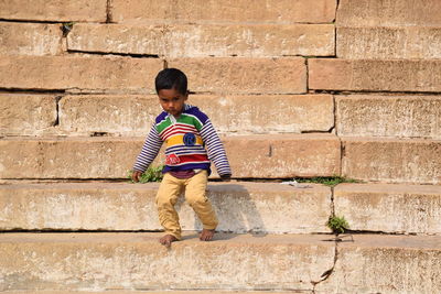 Full length of boy standing against wall
