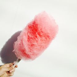 Cropped image of hand holding ice cream against white background