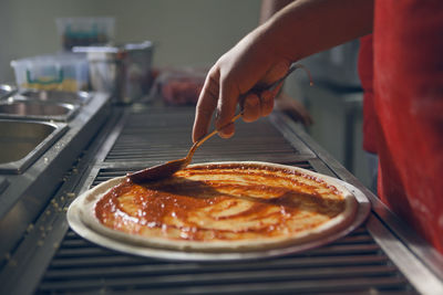 Close-up of hand holding pizza