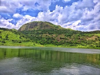 Scenic view of lake by mountain against sky