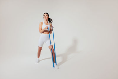 Low section of woman standing against white background