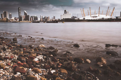 Scenic view of sea by buildings against sky