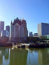 Boats in river with buildings in background