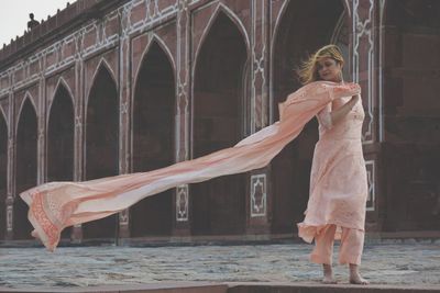 Woman standing against built structure