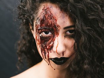 Close-up portrait of young woman with spooky face paint