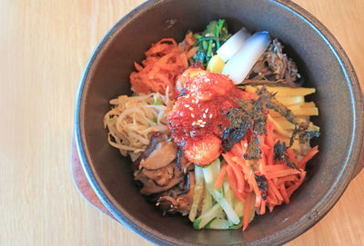 Bibimbap, a flavorful korean traditional mixed rice with meat and vegetables in hot stone bowl