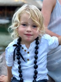 Portrait of smiling boy sitting by woman