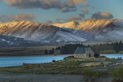 Scenic view of the famous ancient chapel  by snowcapped mountains against sky under  dusk