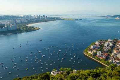 High angle view of city by sea against sky