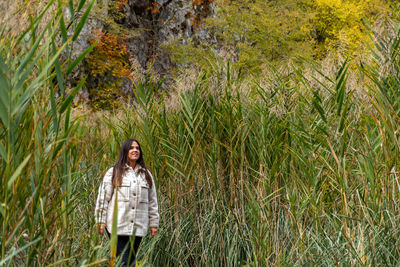 Young woman walking on path surrounded by reed in plitvice lakes national park in croatia