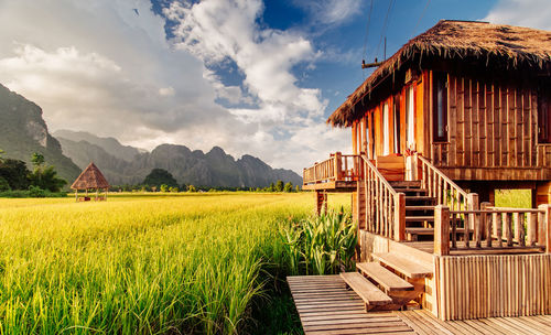 Houses on mountain against cloudy sky