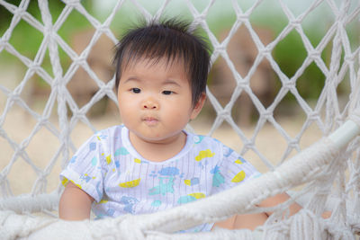 Portrait of cute baby girl behind fence