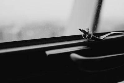 Close-up of wedding rings and fork on window