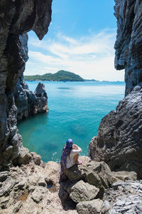 Rock formations by sea against sky