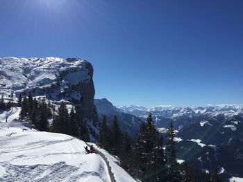 Scenic view of snowcapped mountains against clear blue sky