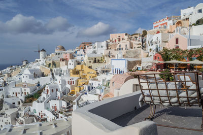 Buildings in town against cloudy sky